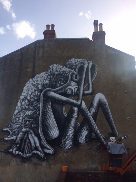 Artist Phlegm at work on his Ventnor Street Art, the mournful giant with Ventnor on his shoulders.