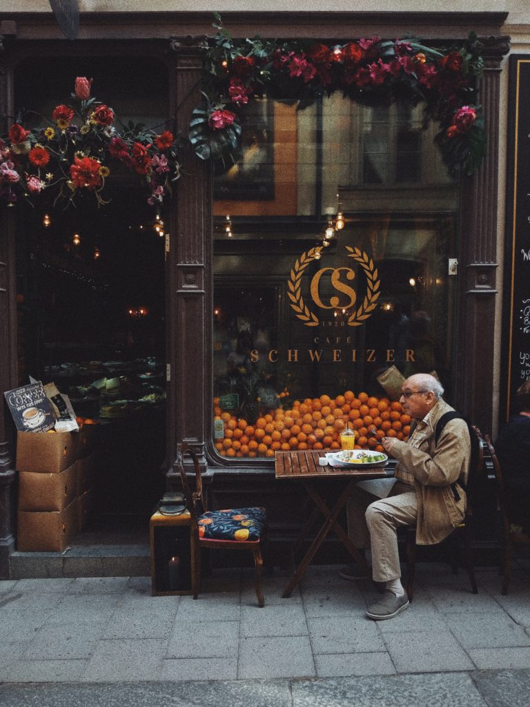 Man eating breakfast at a pavement cafe, picture by Olena Sergienko