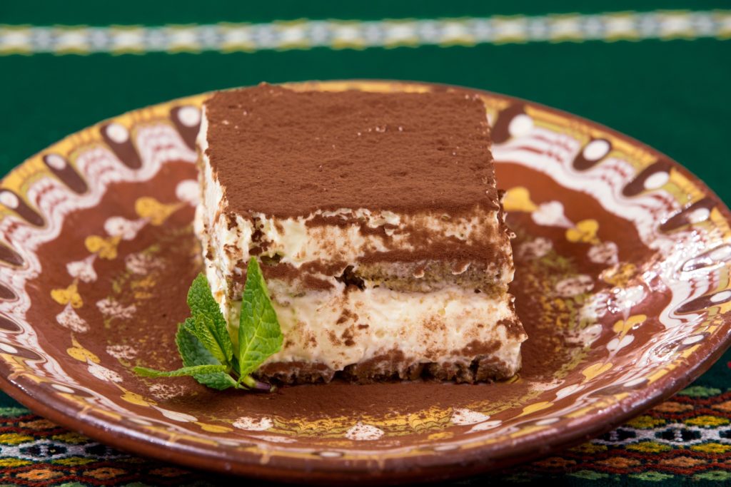 A piece of tiramisu on a brown and yellow plate. Image by pastel100 from Pixabay.